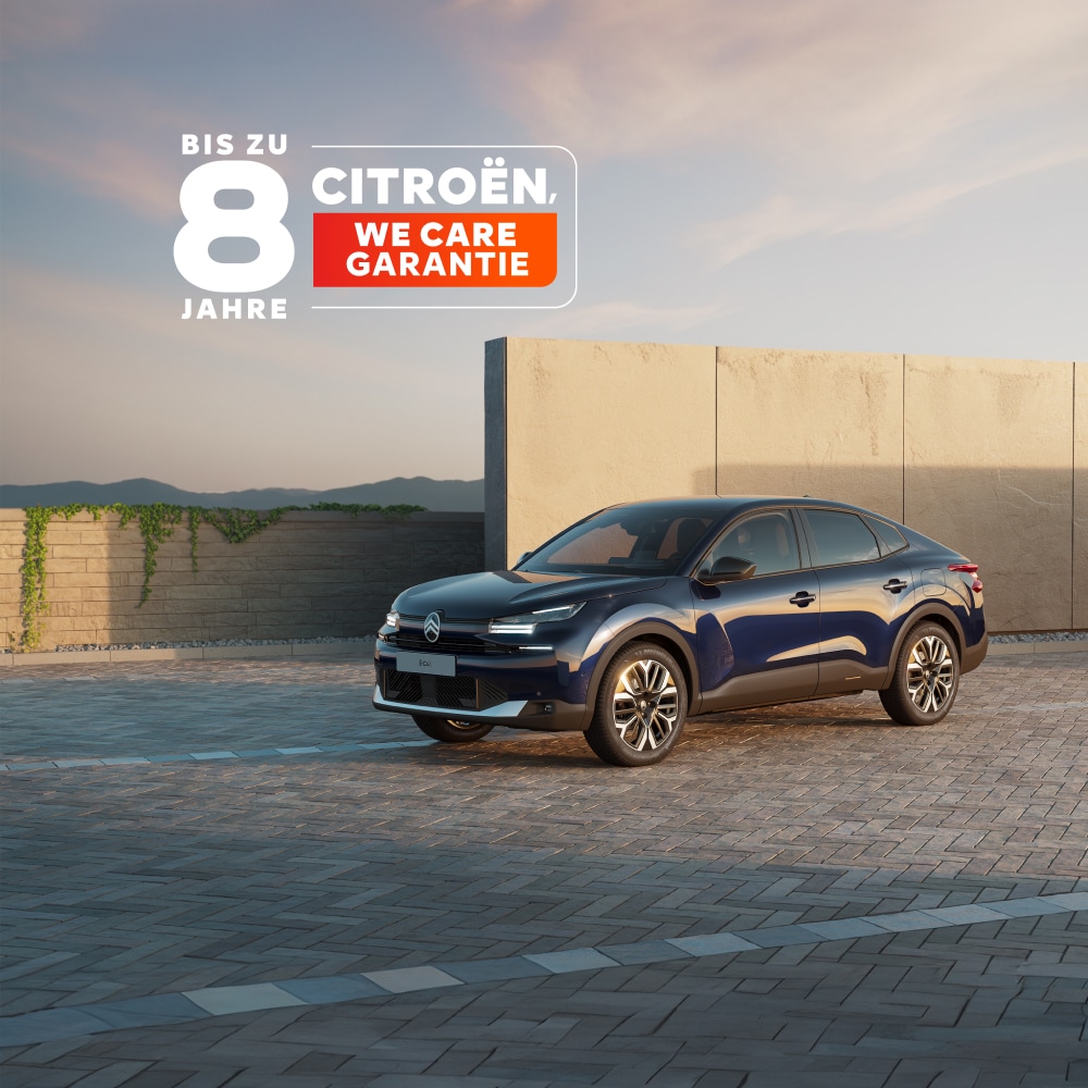 Citroën ë-C4 X fährt bei Sonnenuntergang entlang einer Küstenstraße mit dem Citroën 8-Jahres-Schutz-Abzeichen