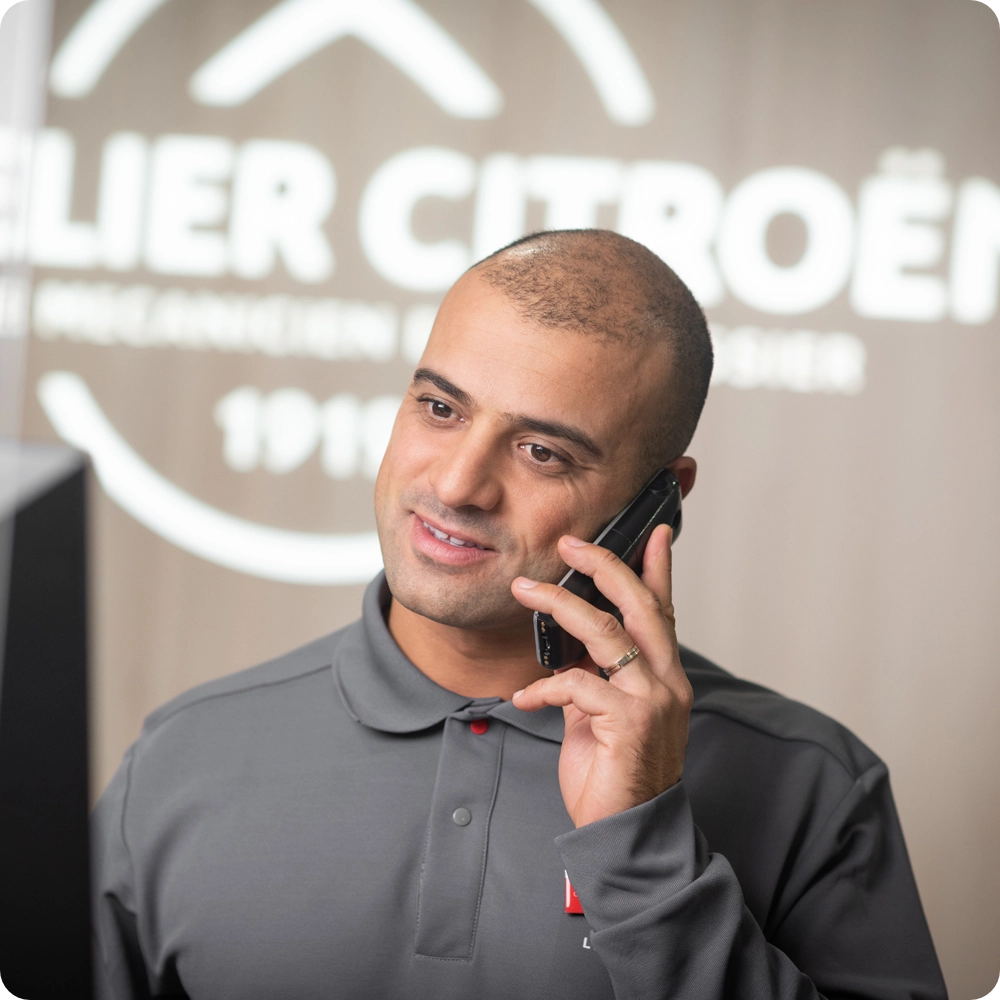 Serviceberater in einer Citroën Werkstatt, der vorbeugende Wartungsdienste und professionelle Unterstützung für Citroën ë-C3 Van Besitzer hervorhebt.