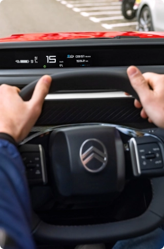 Innenansicht des Citroën ë-C3 Van Cockpits, die das Multifunktionslenkrad und die fahrerorientierten Bedienelemente hervorhebt.