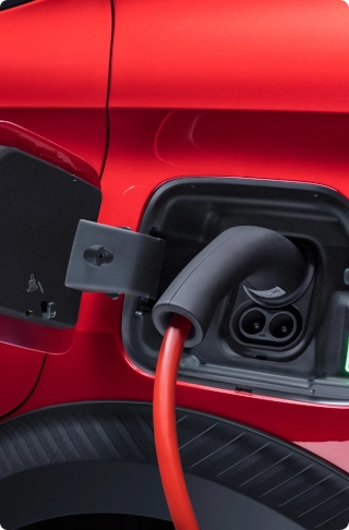 Nahaufnahme des Citroën ë-C3 Van Ladeanschlusses mit angeschlossenem Ladekabel, die Elektromobilität und komfortables Laden hervorhebt.