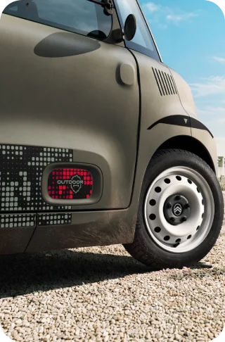 Nahaufnahme der weißen Stahlräder des Citroën Ami Outdoor zeigt das kompakte elektrische Stadtfahrzeug für die tägliche Mobilität