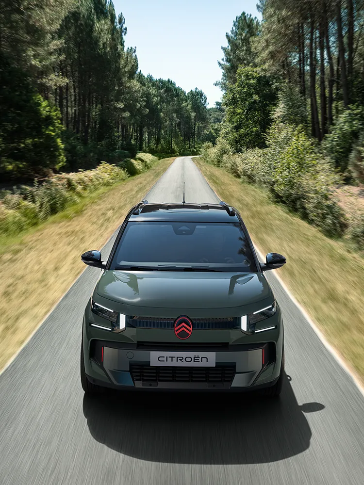 Frontansicht des Citroën C3 Outdoor von oben mit LED-Lichtsignatur zeigt den kompakten SUV mit Advanced Comfort auf einer Waldstraße