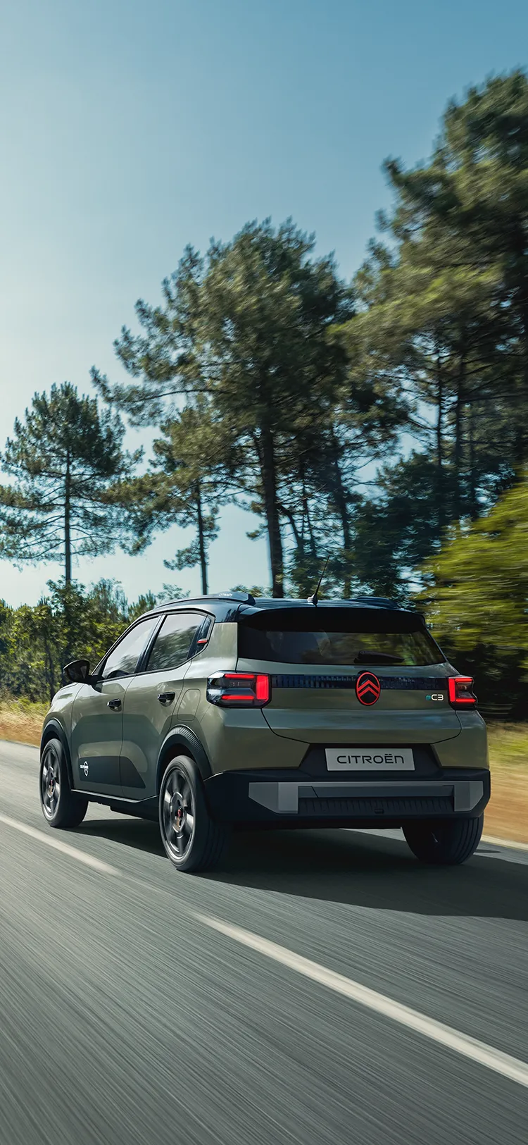 Heck-Dreiviertelansicht des Citroën ë-C3 Outdoor mit LED-Rückleuchten zeigt den Advanced Comfort SUV auf offener Straße