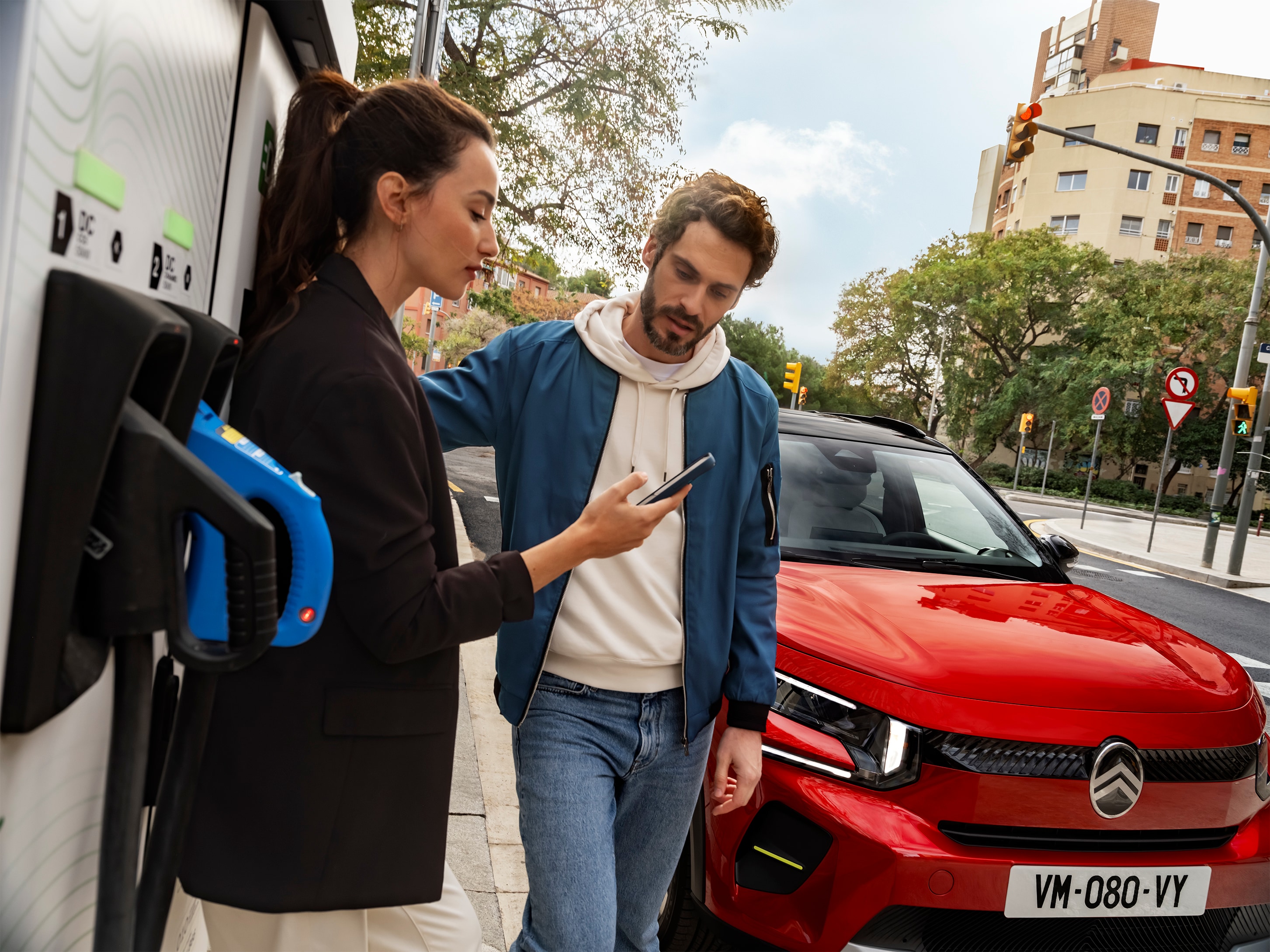 Street Ladeansicht des Citroën ë-C3 Elektro-SUV mit Personen, die Schnellladen vorbereiten für bequeme, effiziente und erschwingliche Stadtmobilität.