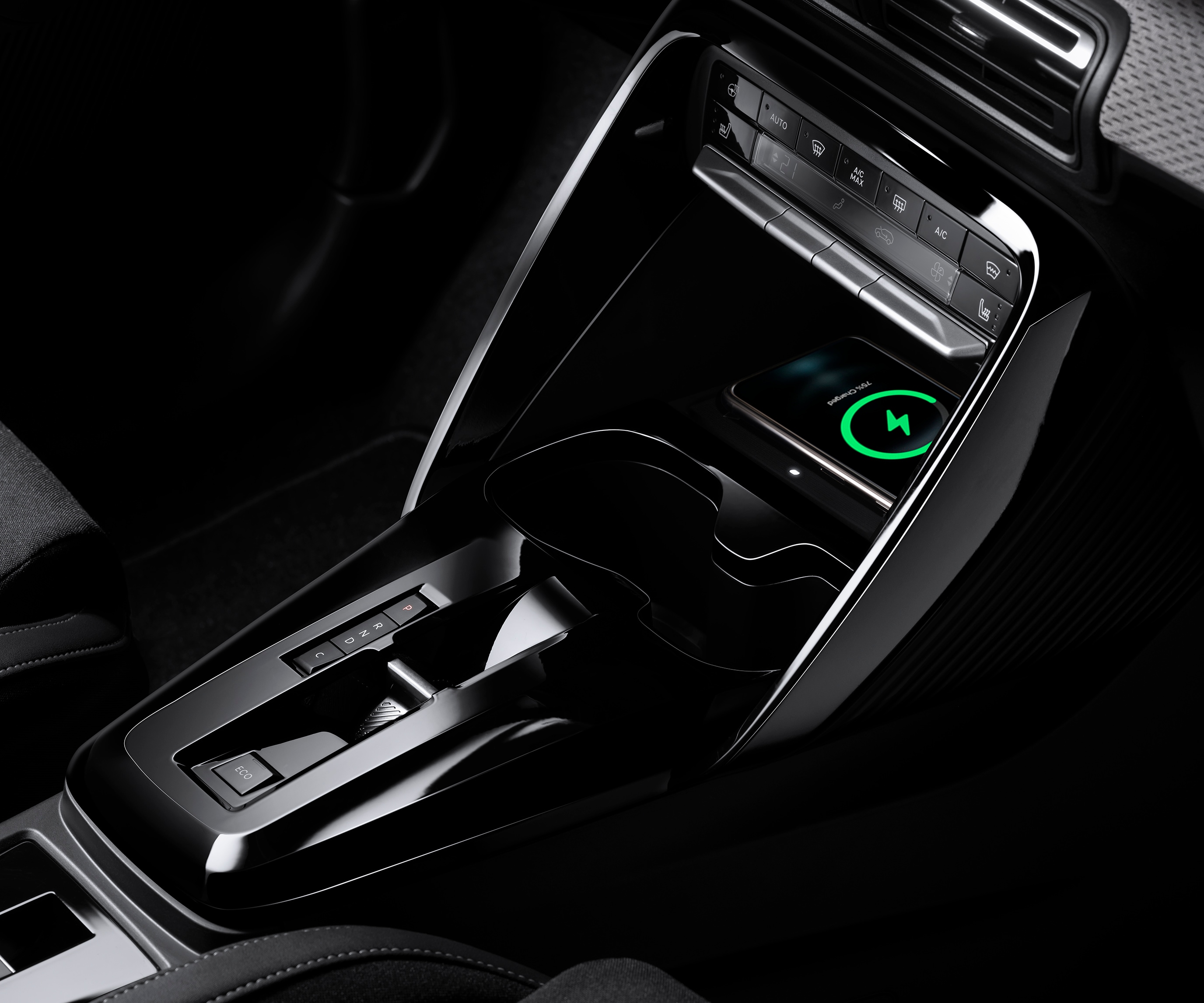 Nahaufnahme der Mittelkonsole des Citroën ë-C3 Elektro-SUV zeigt kabelloses Laden für praktische, erschwingliche Alltagsmobilität.
