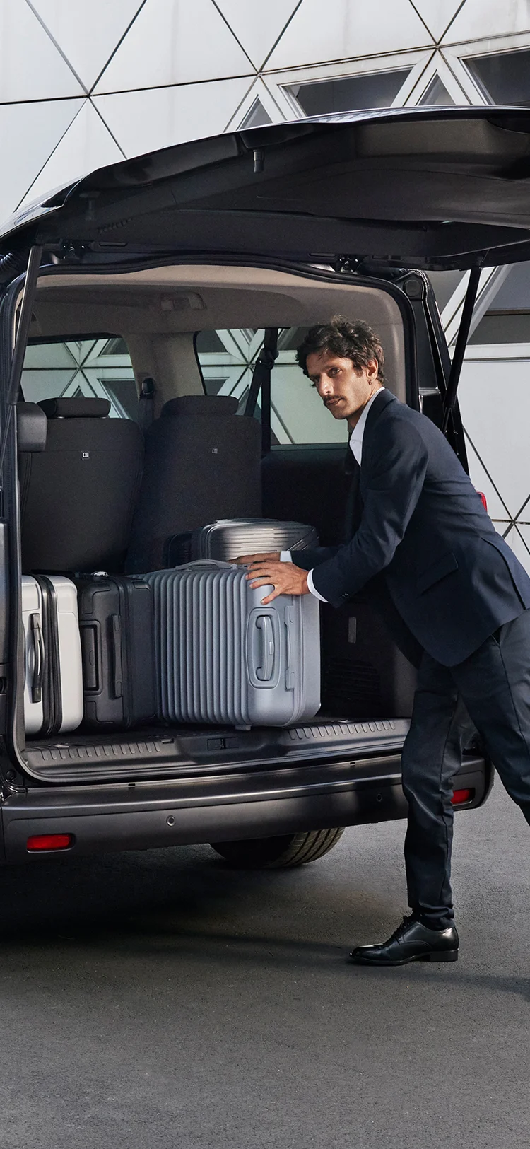 Rear of the Citroën ë‑SpaceTourer with the boot open, showing multiple suitcases being loaded