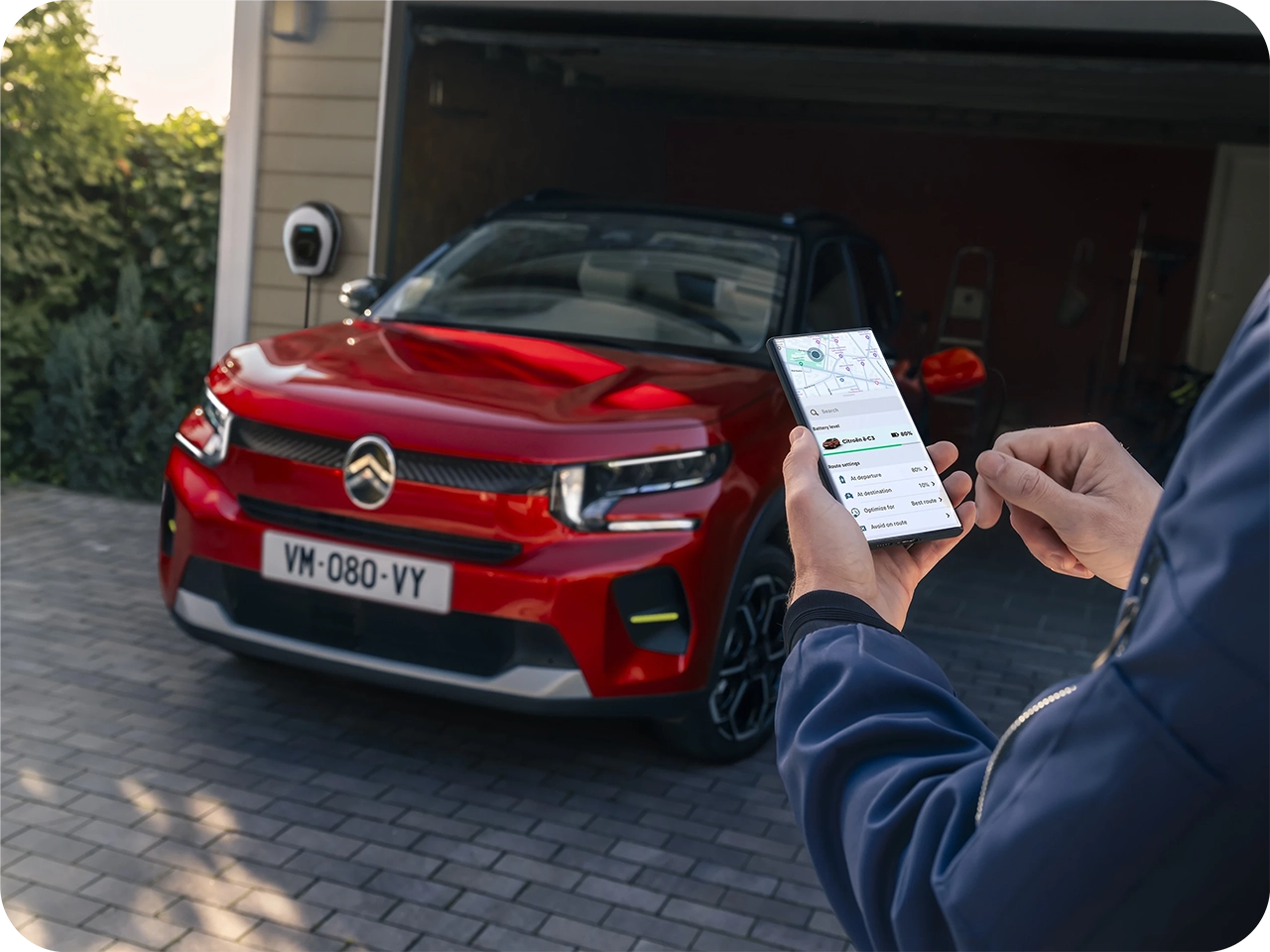 Citroën Fahrzeug geparkt während eine Smartphone-App zur Fernsteuerung von Fahrzeugfunktionen verwendet wird